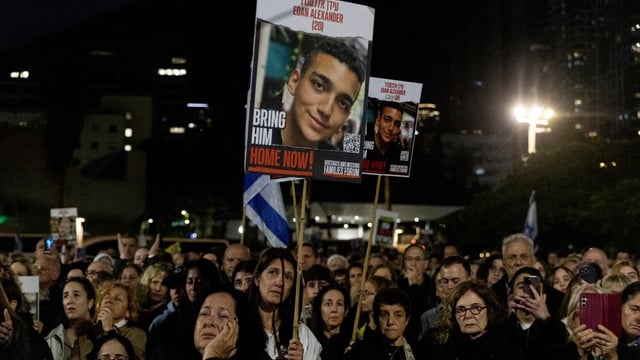 Protesters hold up photos of Eden Alexander during a rally calling on Binyamin Netanyahu to end the war in Gaza