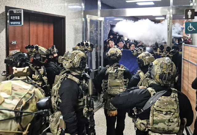 Staff sprays fire extinguishers to block soldiers entering the main hall of the National Assembly in Seoul, South Korea on Dec. 4, 2024. 