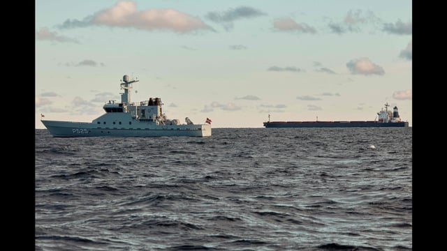The Chinese ship, the bulk carrier Yi Peng 3 (R) is anchored and being monitored by a Danish naval patrol vessels in the sea of Kattegat, near the City og Granaa in Jutland, Denmark, on November 20, 2024. Denmark's navy said on November 20, 2024 it was shadowing a Chinese cargo vessel in the Baltic Sea, a day after Finland and Sweden opened investigations into suspected sabotage of two severed undersea telecoms cables. (Photo by Mikkel Berg Pedersen / Ritzau Scanpix / AFP) / Denmark OUT (AFP)