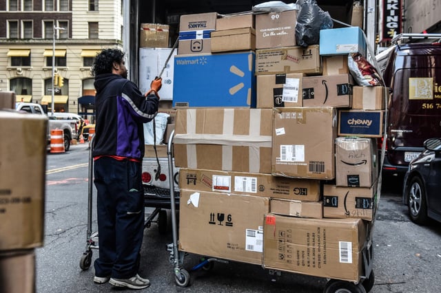 A driver for an independent contractor to FedEx delivers packages in New York on Nov. 27, 2023.