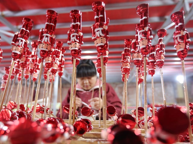 An employee works on the production line of Christmas decorations for export at a workshop in Anhui province, China.
