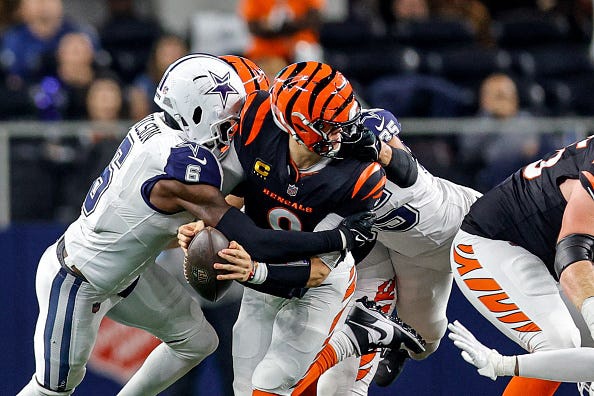 Cincinnati Bengals quarterback Joe Burrow gets sacked by Dallas Cowboys safety Donovan Wilson (6) and linebacker Marist Liufau.