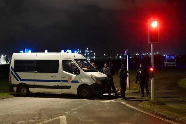 La police française bloque une route près d'un camp de migrants où deux agents de sécurité et deux migrants ont été abattus près de Dunkerque (Nord), le 14 décembre 2024.