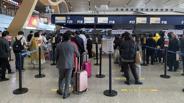 Travelers wait in line at a check-in counter at Kunming Changshui International Airport, Kunming, China, March 22, 2022 (AP photo by Dake Kang).