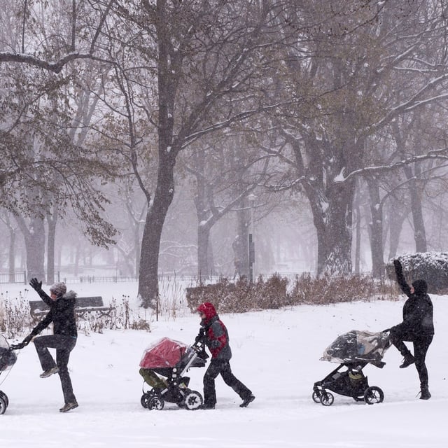 A group of women push their baby carriages along a park path in Montreal, Tuesday, Dec. 12, 2017, as they brave a snowfall for an exercise session. THE CANADIAN PRESS/Paul Chiasson