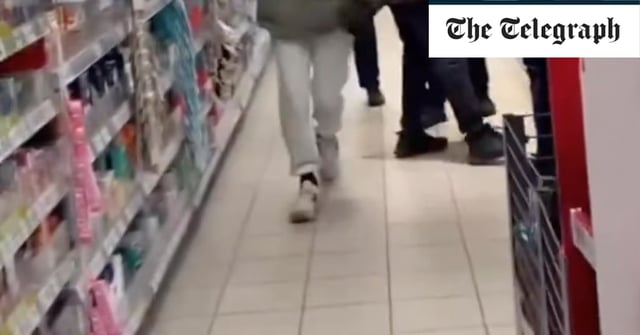 A Tesco worker kicks a shoplifter as he flees with bottle of wine in Kilburn, north London