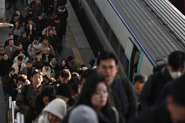 Commuters disembark from a train at a train station in Seoul on December 6, 2024.