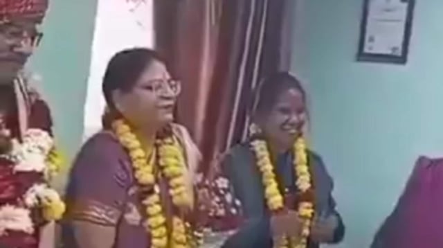 Both the husband and wife (second and second L) were seen wearing garlands and smiling during his farewell at office. 