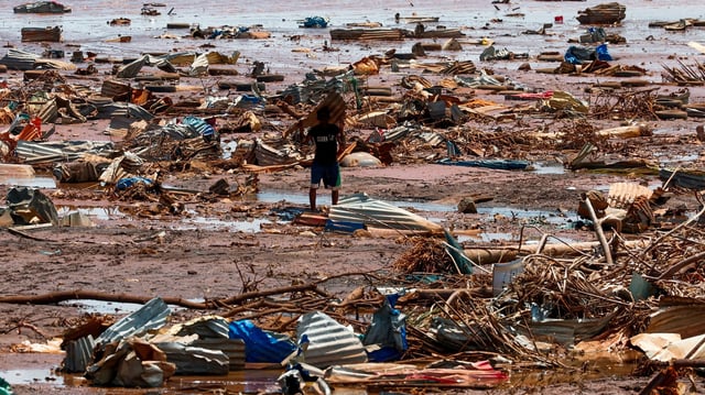 Un garçon porte une plaque de toiture sur la plage après le passage du cyclone Chido, à Passamainty, Mayotte, France, le 20 décembre 2024.
