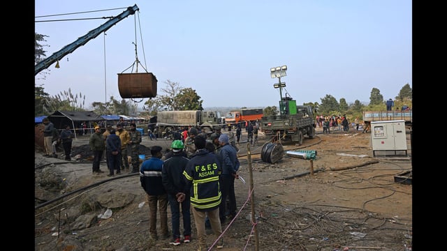 Rescue workers and others stand near a coal mine where at least nine miners became trapped on Monday, in Umrangso area of Dimapur Hasao district in northeastern state of Assam. (AP PHOTO)