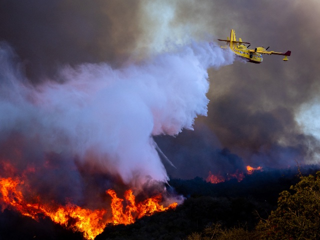 A Super Scooper drops ocean water on a hillside as the Palisades fire rages on Tuesday, Jan. 7, 2025 in Pacific Palisades, CA. (Brian van der Brug / Los Angeles Times via Getty)