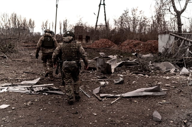 Soldiers walk among damaged structures and metal fragments as civilians are being evacuated from the Pokrovsk, Ukraine on January 08, 2025.