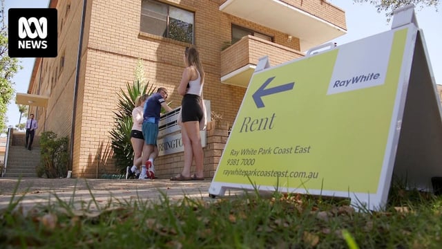 Rent sign outside apartment inspection site with people lining up