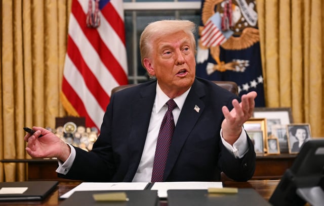 President Donald Trump signs an executive order in the Oval Office on Jan. 20, 2025. 