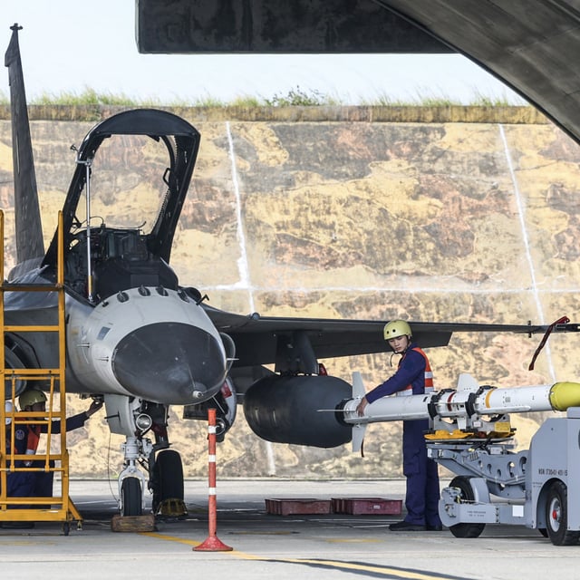 Taiwanese air force ground crews mount a missile onto an Indigenous Defense Fighter aircraft as part of a combat readiness exercise at Ching Chuan Kang Air Base in Taichung on January 8, 2025.