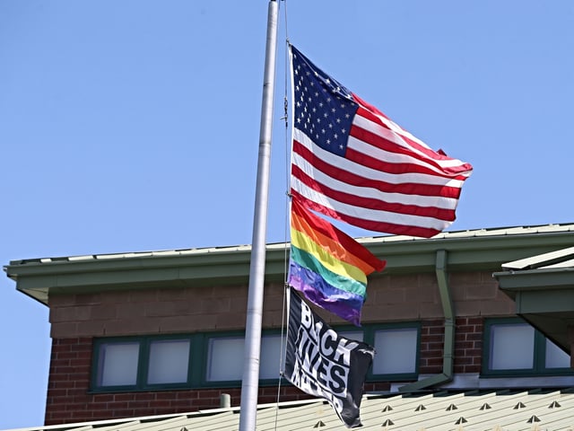 Worcester, MA - July 19: The US flag, the rainbow pride flag and a Black Lives Matter flag fly over The Nativity School of Worcester. Bishop Robert J. McManus, of the Diocese of Worcester, stripped the all-boys middle school of its right to call itself Catholic over its refusal to take down the pride and BLM flags. (Photo by Jonathan Wiggs/The Boston Globe via Getty Images)