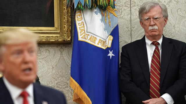 Former White House National Security Advisor John Bolton listens to President Donald Trump in 2019.