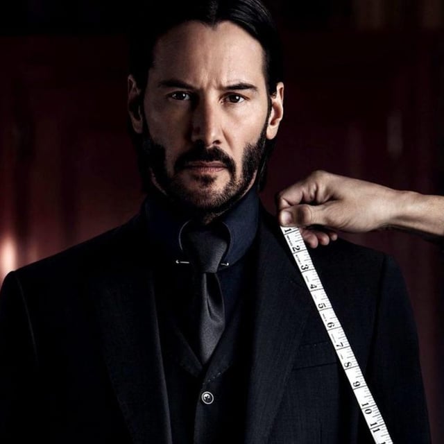 Keanu Reeves getting measured for a suit in John Wick