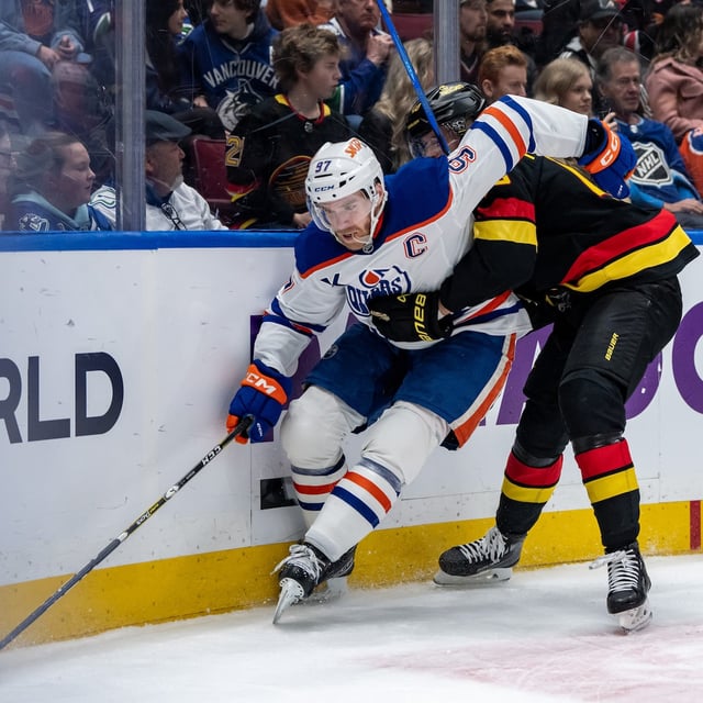 Edmonton Oilers' Connor McDavid (97) and Vancouver Canucks' Elias Pettersson (40) vie for the puck during third period NHL hockey action in Vancouver, B.C., Saturday, Jan. 18, 2025. THE CANADIAN PRESS/Ethan Cairns