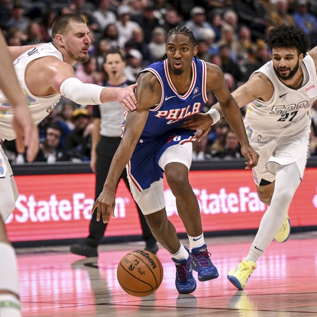 Tyrese Maxey (0) of the Philadelphia 76ers drives between Nikola Jokic (15) and Jamal Murray (27) of the Denver Nuggets during the third quarter at Ball Arena in Denver, Colorado on Tuesday, January 21, 2025.