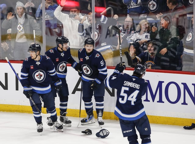 Winnipeg Jets' Vladislav Namestnikov (7), Nikolaj Ehlers (27), Cole Perfetti (91) and Dylan Samberg (54) celebrate Perfetti's hat-trick against the Utah Hockey Club during third period NHL action in Winnipeg on Friday, January 24, 2025. THE CANADIAN PRESS/John Woods