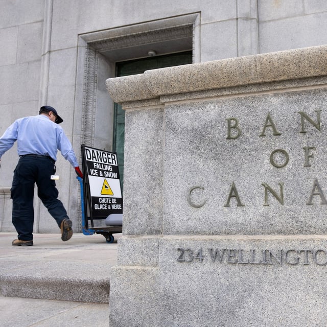 Economists expect the annual inflation rate in December fell to 1.7 per cent, easing further from the previous month and setting up the Bank of Canada to continue cutting interest rates. A worker rolls signs past the Bank of Canada, Wednesday, April 10, 2024 in Ottawa. THE CANADIAN PRESS/Adrian Wyld
