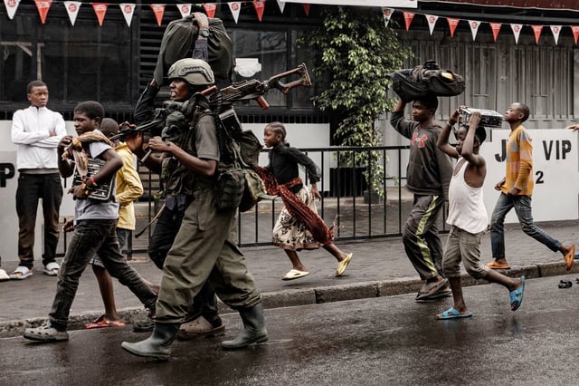 Un soldat du groupe rebelle M23 et des habitants de Goma, le 27 janvier.