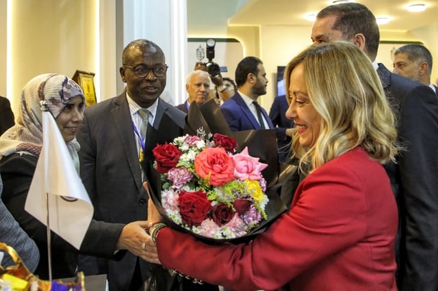 La Première ministre italienne Giorgia Meloni reçoit un bouquet de fleurs lors de sa tournée avec le Premier ministre du Gouvernement d'unité nationale (GNU) libyen, Abdulhamid Dbeibah, le 29 octobre 2024.