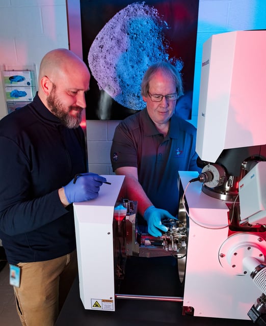 Rob Wardell (left) and Dr. Tim McCoy from the department of mineral sciences at the Smithsonian's National Museum of Natural History in Washington, DC, place a sample of the asteroid Bennu into a Thermo Fisher FEI Quattro Analytical Scanning Electron Microscope for analysis.