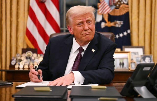 President Donald Trump signs executive orders in the Oval Office of the White House in Washington, DC, on January 20, 2025.