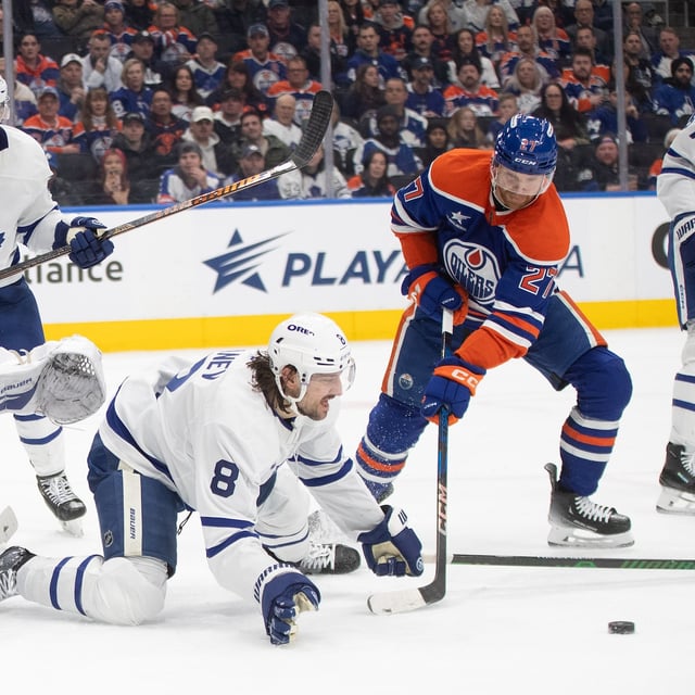 Toronto Maple Leafs' Christopher Tanev (8) blocks a shot as Edmonton Oilers' Brett Kulak (27) looks for the loose puck and goalie Joseph Woll (60) prepares to make a save during second period NHL action in Edmonton, Saturday, Feb. 1, 2025. THE CANADIAN PRESS/Jason Franson