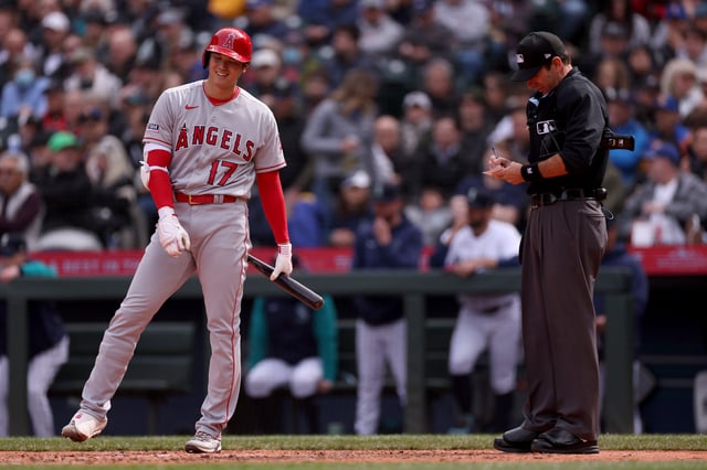 Umpire Pat Hoberg #31 calls Shohei Ohtani #17 of the Los Angeles Angels for a pitch clock violation during the sixth inning against the Seattle Mariners at T-Mobile Park on April 05, 2023 in Seattle, Washington.