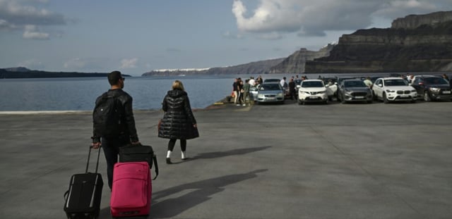 Des touristes et automobilistes attendent l'arrivée du ferry pour quitter l'île de Santorin, en Grèce, après des tremblements de terre récurrents, le 3 février 2025