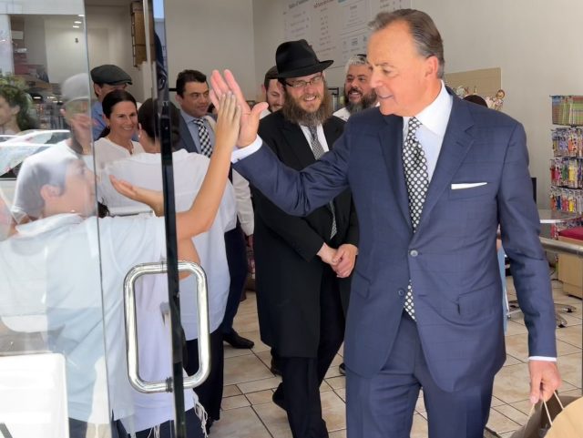 Rick Caruso high-fives a young supporter at Munchie's kosher candy store during a visit to the heavily Jewish Pico-Robertson neighborhood in Los Angeles, May 31, 2022. (Joel Pollak / Breitbart News)
