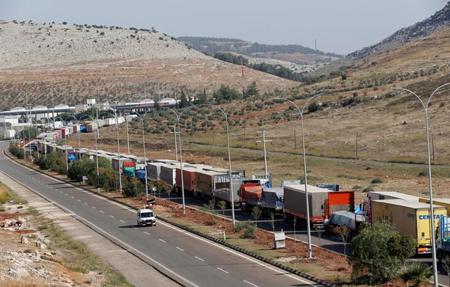 Turkish trucks transporting sacks of cement wait to cross to Syria near the Cilvegozu border gate which is located opposite the Syrian commercial crossing point Bab al-Hawa, in Hatay province, Turkey November 1, 2012. REUTERS/Murad Sezer/File Photo