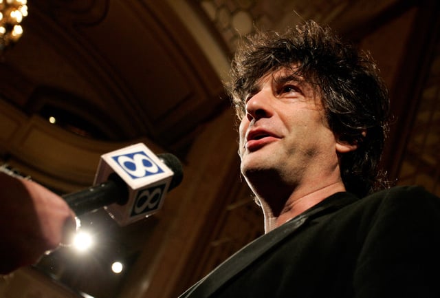 British author Neil Gaiman talks to a reporter as he arrives at the premiere of the animated movie "Coraline" in Portland, Oregon February 5, 2009. REUTERS/Richard Clement/File Photo