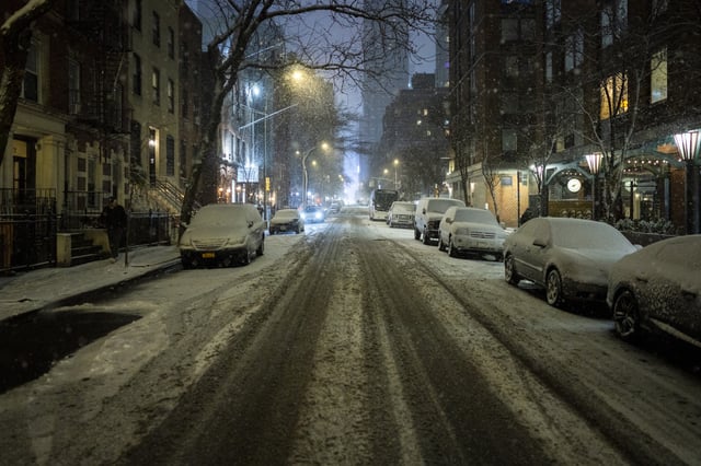 Snow begins to cover the streets and cars in Hell&#39;s Kitchen during the night on January 19, 2025 in New York City.