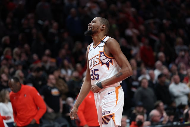 Feb 3, 2025; Portland, Oregon, USA;  Phoenix Suns forward Kevin Durant (35) laughs as he watches a replay of his teammate SunsÕ guard Devin Booker (1) being fouled by Portland Trail Blazers forward Deni Avdija (8) in overtime at Moda Center. Mandatory Credit: Jaime Valdez-Imagn Images