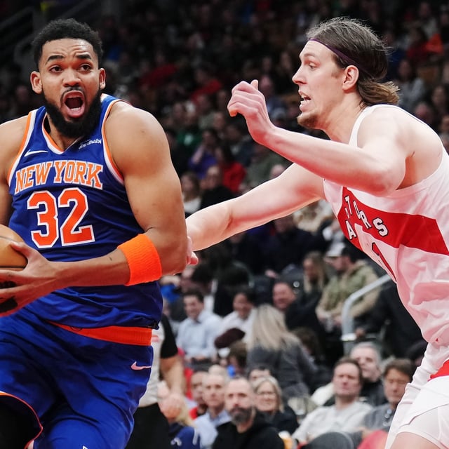 New York Knicks' Karl-Anthony Towns (left) drives at Toronto Raptors' Kelly Olynyk (right) during second half NBA basketball action in Toronto on Tuesday, Feb. 4, 2025. THE CANADIAN PRESS/Nathan Denette