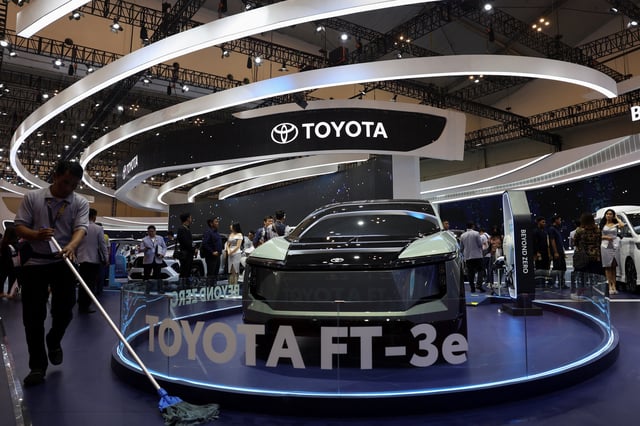 A man mops a floor near a Toyota FT-3e during the Indonesia International Auto Show in Tangerang, Indonesia, July 18, 2024. REUTERS/Ajeng Dinar Ulfiana/File Photo