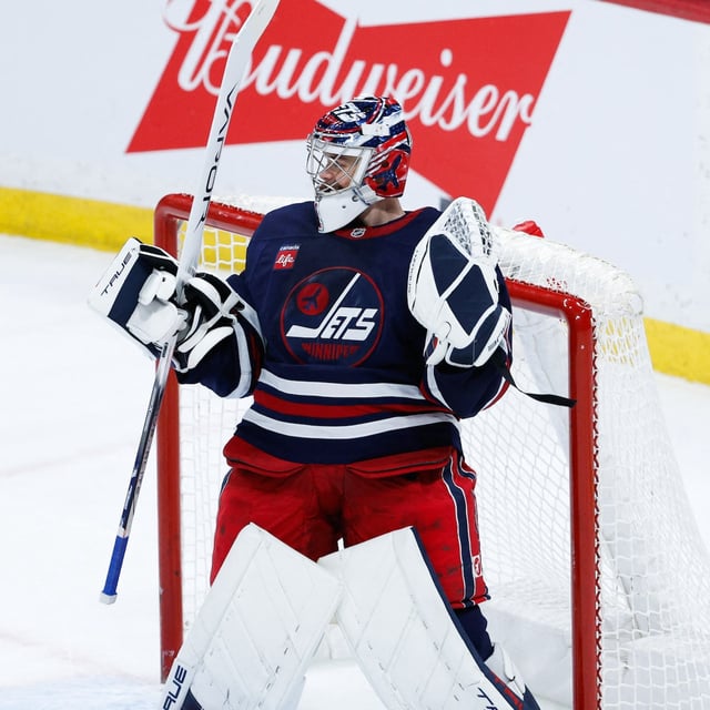 Feb 4, 2025; Winnipeg, Manitoba, CAN;  Winnipeg Jets goalie Eric Comrie (1) celebrates his win against the Carolina Hurricanes at the end of the third period at Canada Life Centre. Mandatory Credit: Terrence Lee-Imagn Images