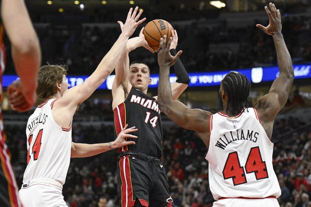 Feb 4, 2025; Chicago, Illinois, USA;  Miami Heat guard Tyler Herro (14) passes the ball away from Chicago Bulls forward Matas Buzelis (14) and forward Patrick Williams (44) during the second half at United Center. Mandatory Credit: Matt Marton-Imagn Images