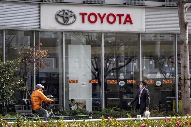 Pedestrians walk past a car dealership for Japanese automaker Toyota in Tokyo on Feb. 5, 2025