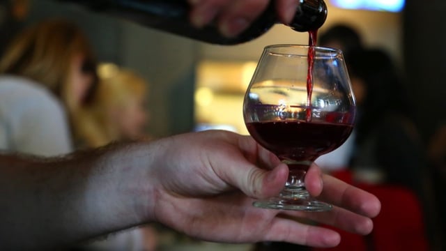 hand holding glass while other hand pours sour beer into it