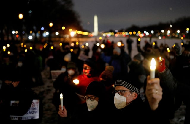People hold up candles during a candlelight vigil on the National Mall in observance of the first anniversary of the January 6, 2021 attack on the Capitol by supporters of former President Donald Trump, on Capitol Hill in Washington, U.S., January 6, 2022. REUTERS/Tom Brenner/File Photo