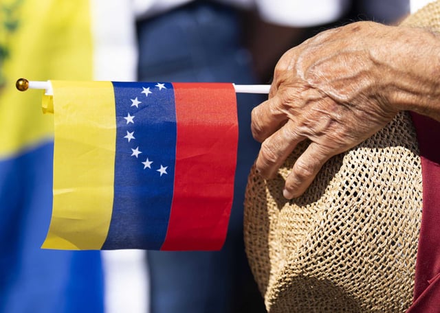 Henry Melinda inserts a Venezuelan flag into his hat as speakers take turns addressing the crowd as he and others join a global outcry in responded to a call from their country’s political opposition claim to victory over President Nicolás Maduro in last month’s disputed presidential election at Bendwood Park, Saturday, Sept. 28, 2024, in Houston.