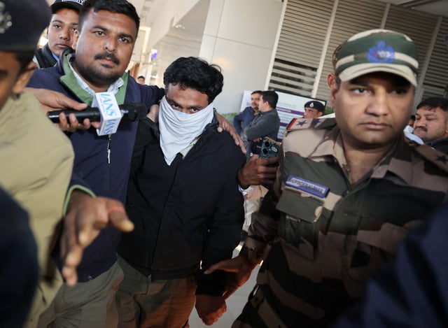 Security personnel escort an Indian immigrant deported from the U.S. as they leave the airport in Ahmedabad, India February 6, 2025. REUTERS/Amit Dave