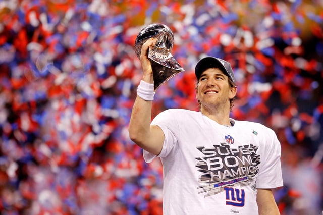 Quarterback Eli Manning of the New York Giants poses with the Vince Lombardi Trophy after the Giants defeated the Patriots by a score of 21-17 in Super Bowl XLVI at Lucas Oil Stadium on February 5, 2012 in Indianapolis, Indiana.