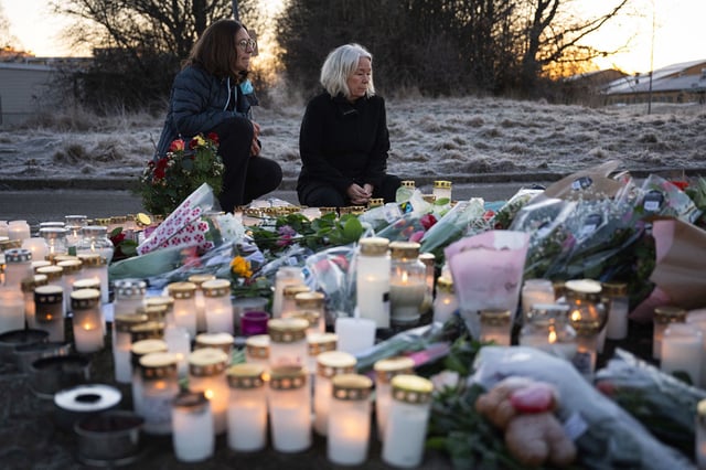 People light candles at a makeshift vigil near the scene of the shooting on February 6.