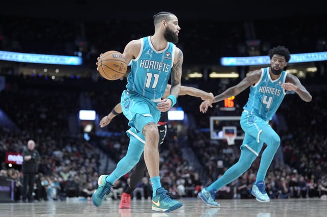 Cody Martin #11 of the Charlotte Hornets moves the ball during the first half against the Portland Trail Blazers at Moda Center on February 25, 2024 in Portland, Oregon.